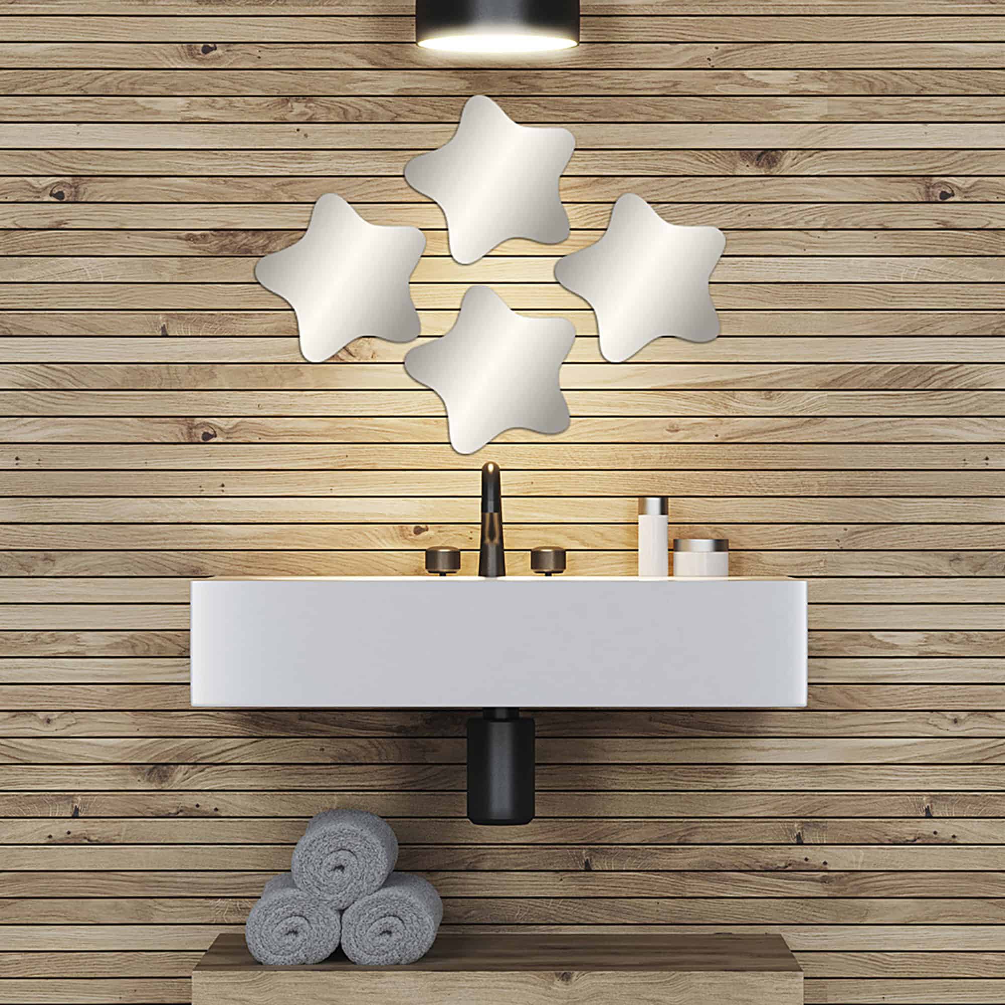 "Four rounded star-shaped frameless mirrors in loose cluster above a floating bathroom vanity with wood plank wall"