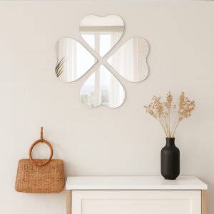 "Four heart-shaped mirrors in four-leaf clover arrangement on a wall above a white console table in an entryway"