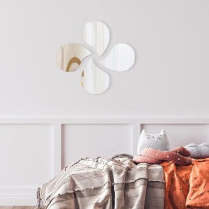 "Four teardrop-shaped mirrors in pinwheel arrangement above a children's bedroom bed"