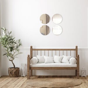 "Four large round frameless mirrors in 2x2 grid above a rustic wooden bench in a farmhouse-style room"