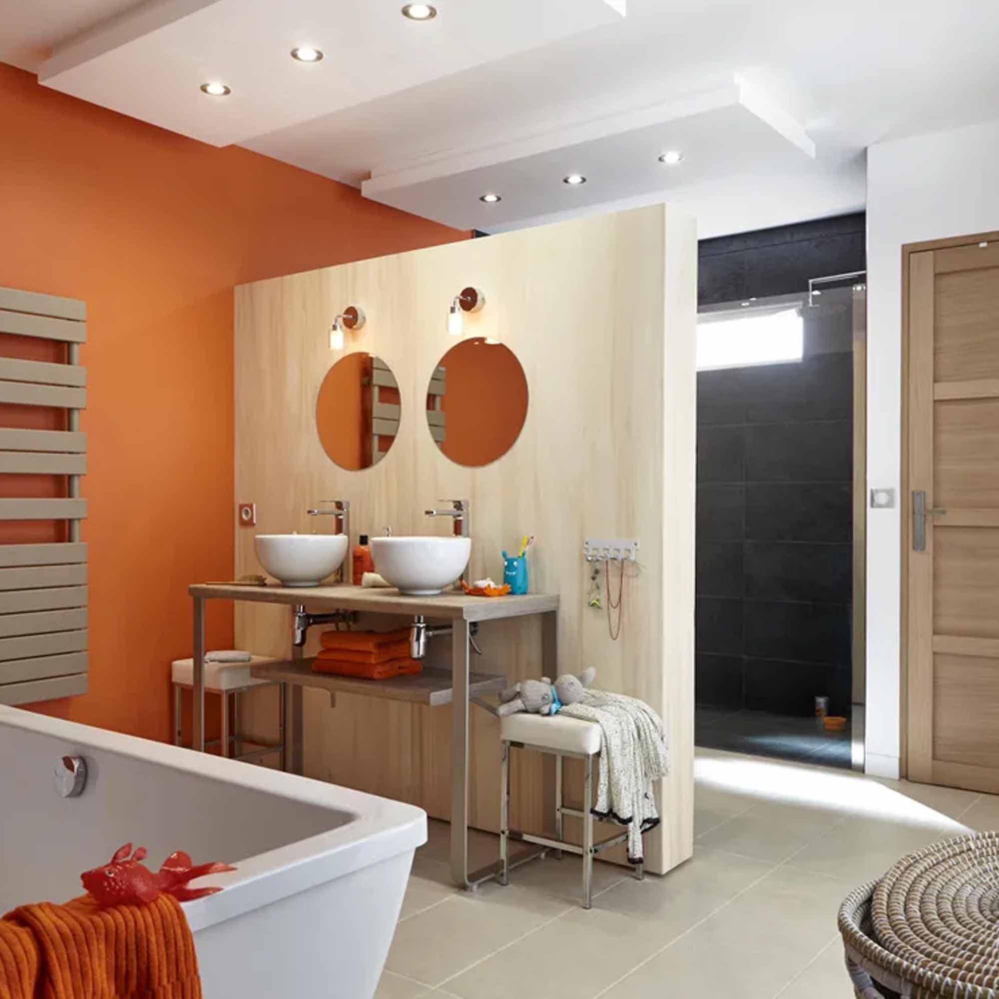 "Two large round frameless mirrors side by side above a double vessel sink vanity in a colorful bathroom"