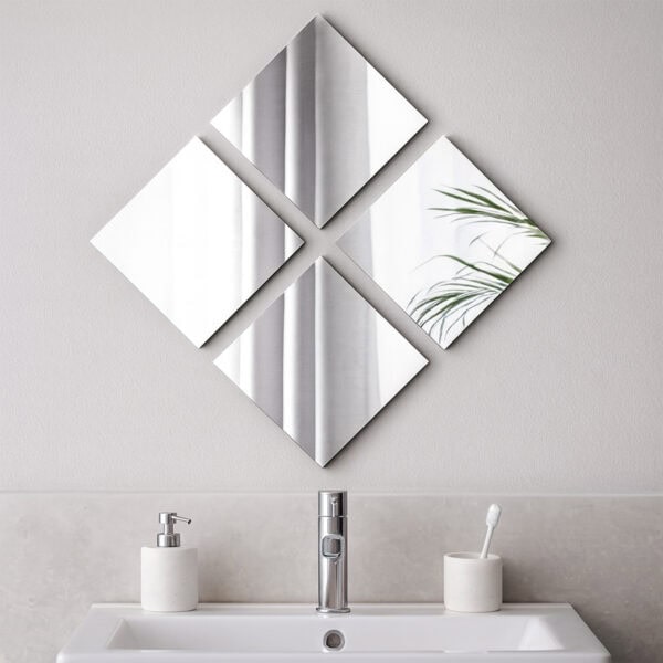 "Four large square frameless mirrors arranged in diamond pattern above a bathroom sink"