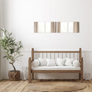 "Four large square frameless mirrors in horizontal row above a rustic wooden bench in a farmhouse-style room"