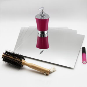 "Four stacked large square frameless mirrors lying flat beside a hairbrush and cosmetics"