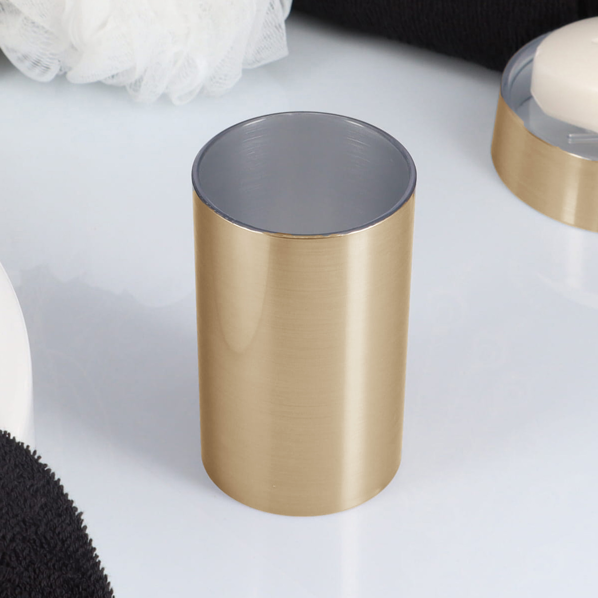 Brushed gold bathroom tumbler close-up on countertop