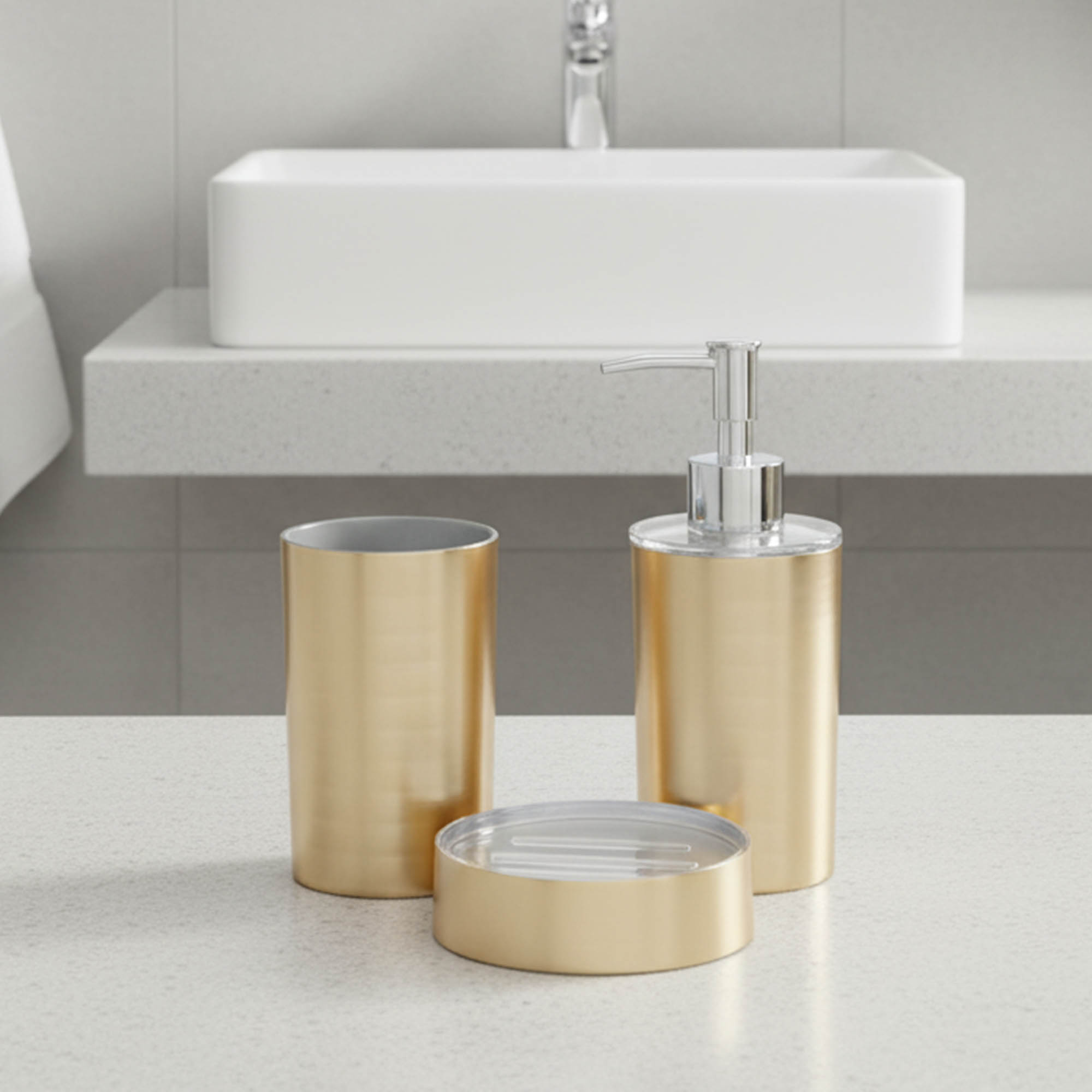 Brushed gold bathroom accessory set arranged on white background