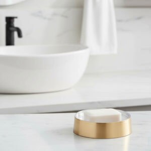 Brushed gold soap dish with clear base on bathroom counter