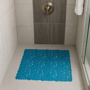 Peacock blue bubble-pattern shower mat on beige tile shower floor with brushed nickel fixtures and glass door