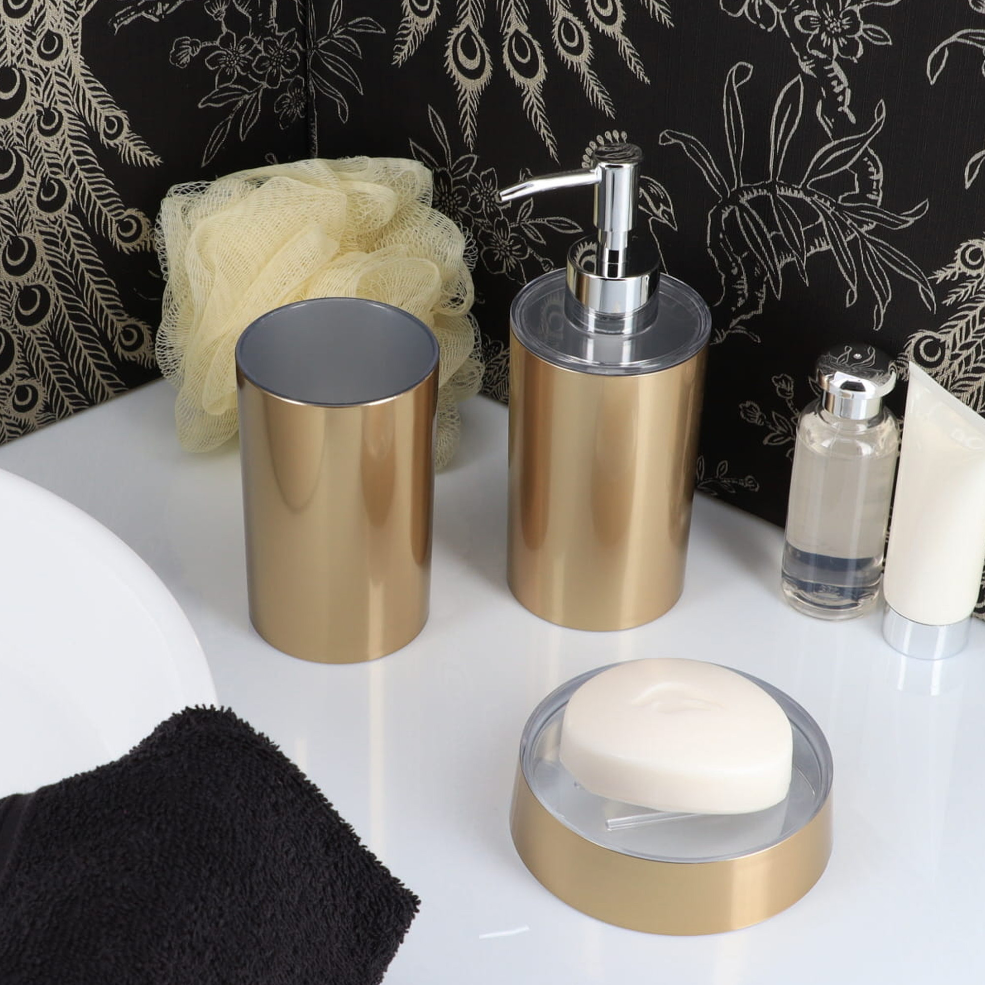 “Brushed gold soap dispenser, tumbler, and dish in bathroom setting”