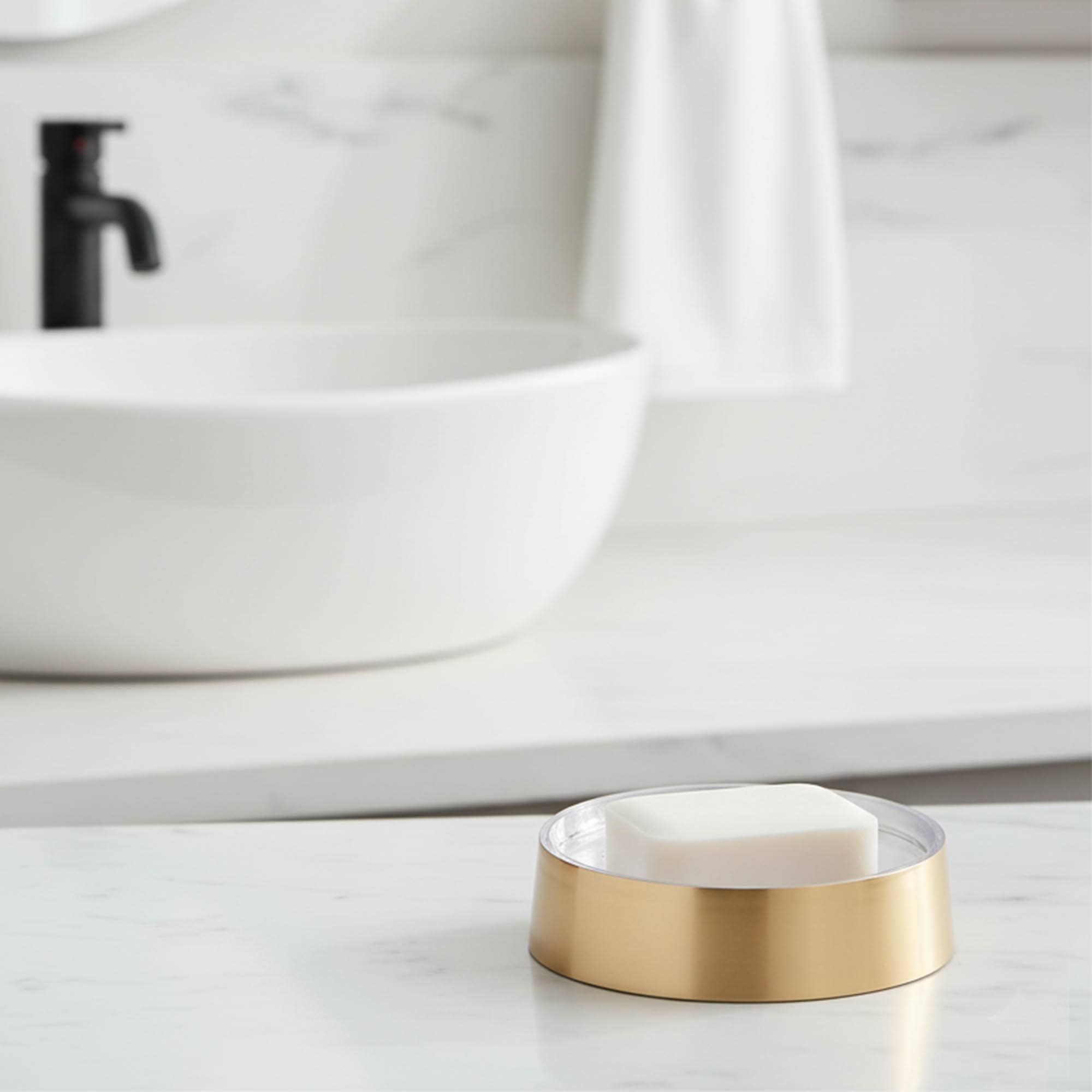“Brushed gold soap dish with bar soap on bathroom counter”