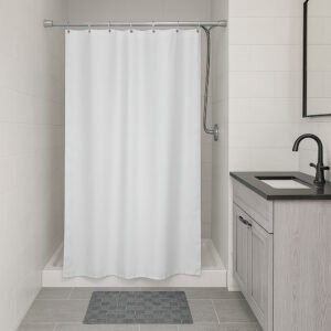 White stall-size shower curtain hanging in compact bathroom
