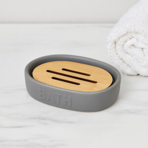 Grey soap dish with bamboo insert on bathroom counter