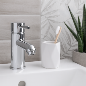 White stoneware bathroom tumbler with toothbrush on sink