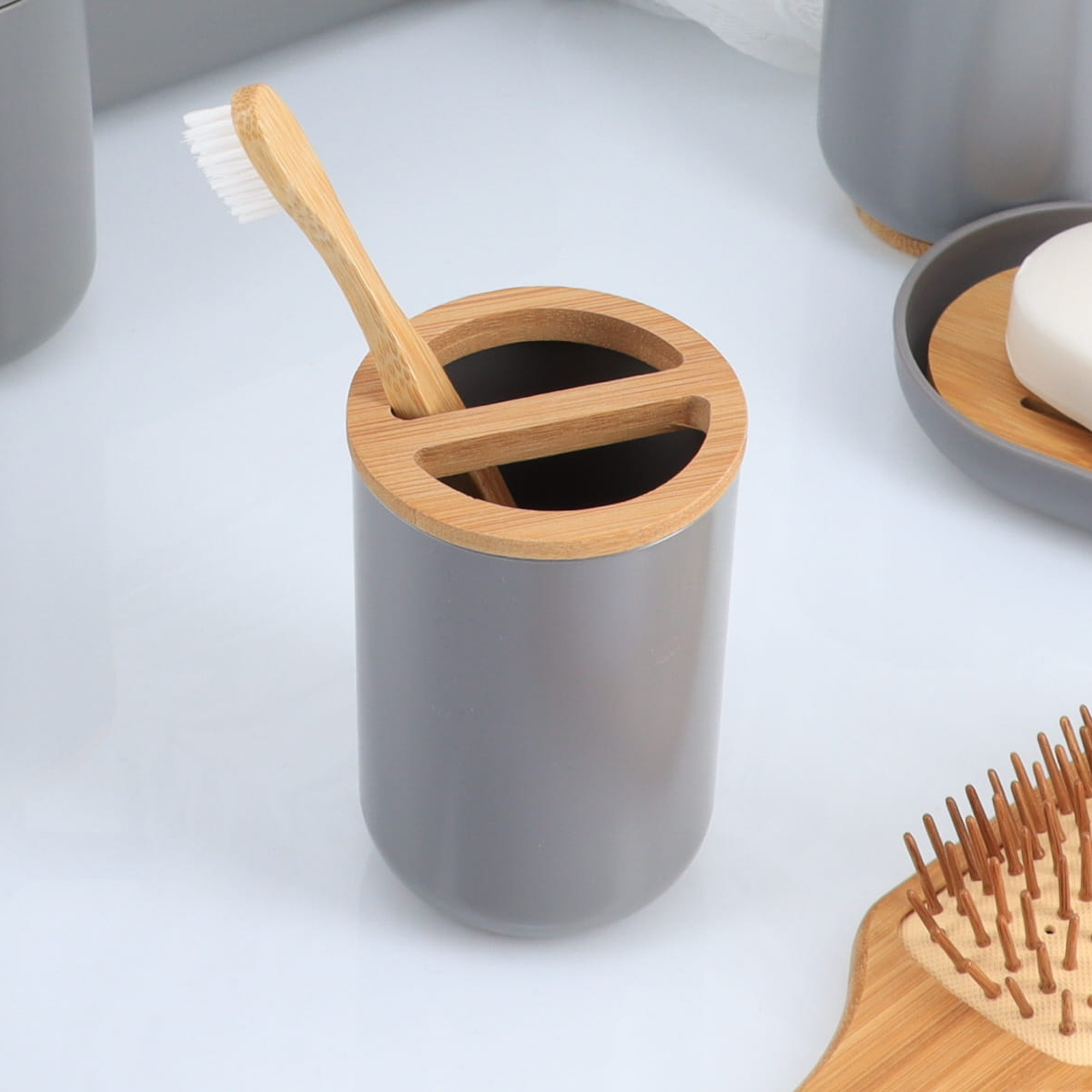 Bamboo toothbrush placed inside gray bathroom toothbrush holder