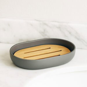 Empty gray soap dish with slotted bamboo tray on marble surface
