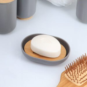 Gray bamboo soap dish holding white soap bar with matching accessories