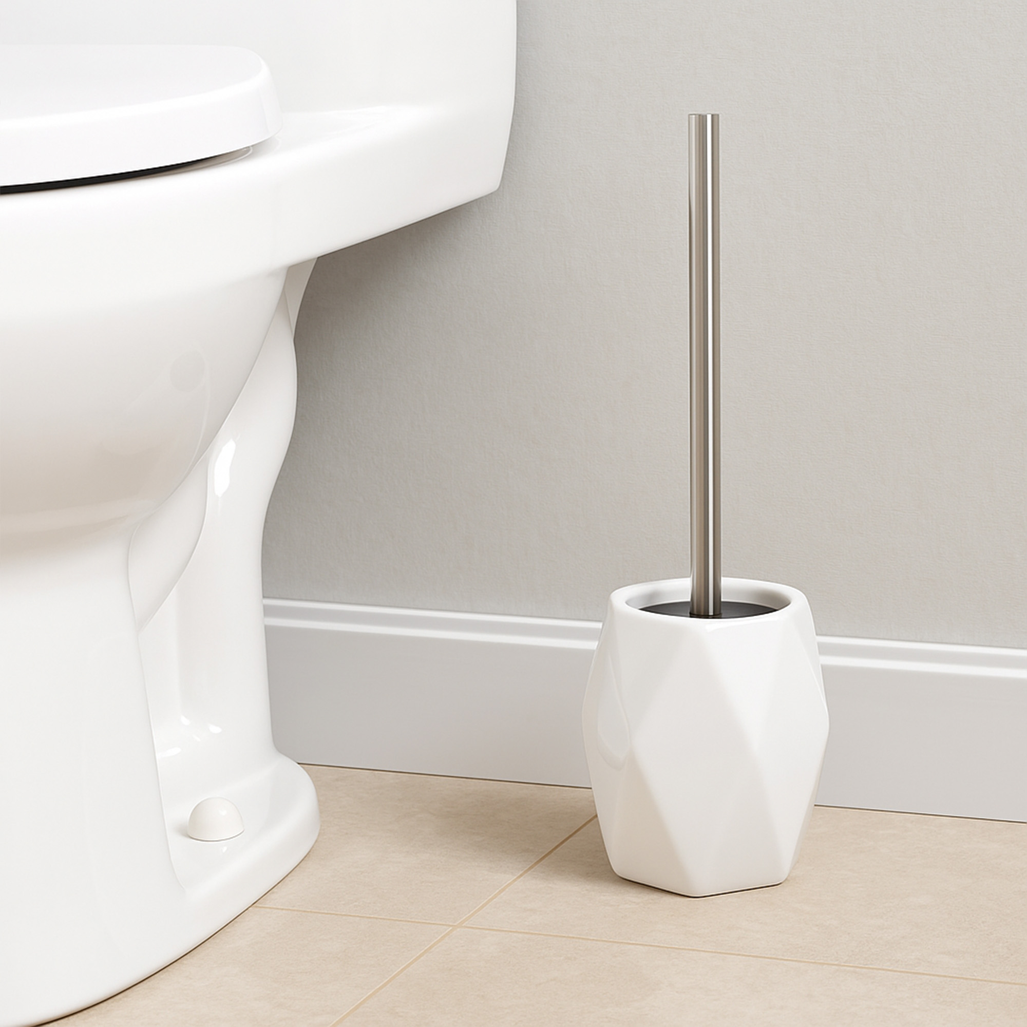 White diamond-shaped stoneware toilet brush holder beside white toilet against beige wall