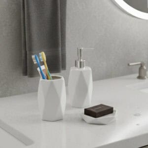 3. “White geometric soap dispenser and tumbler on bathroom sink”