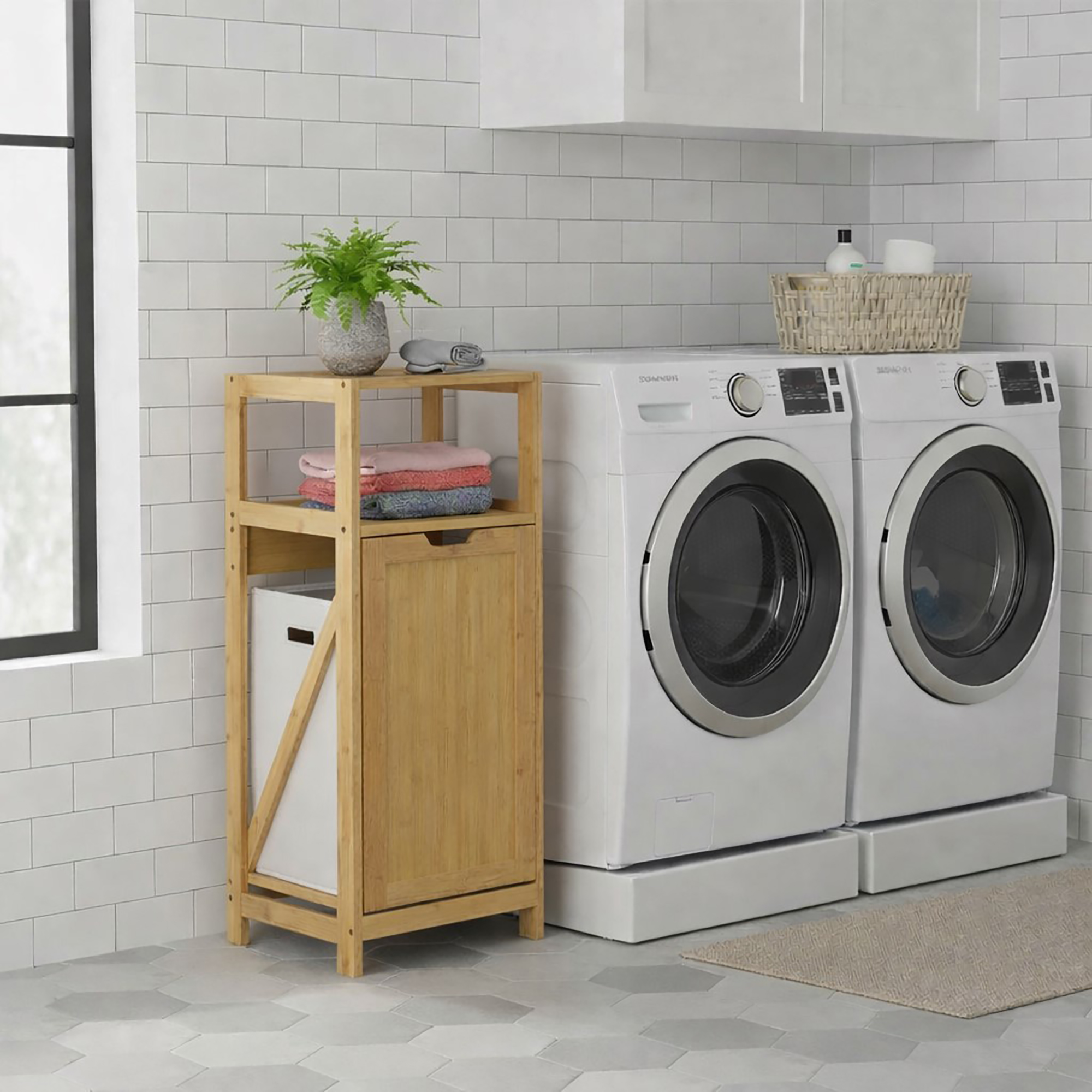 Bamboo laundry cabinet with open hamper next to front-load washer and dryer in a modern laundry room