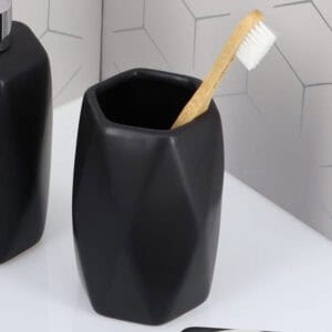 Matte black bathroom tumbler close-up with toothbrush