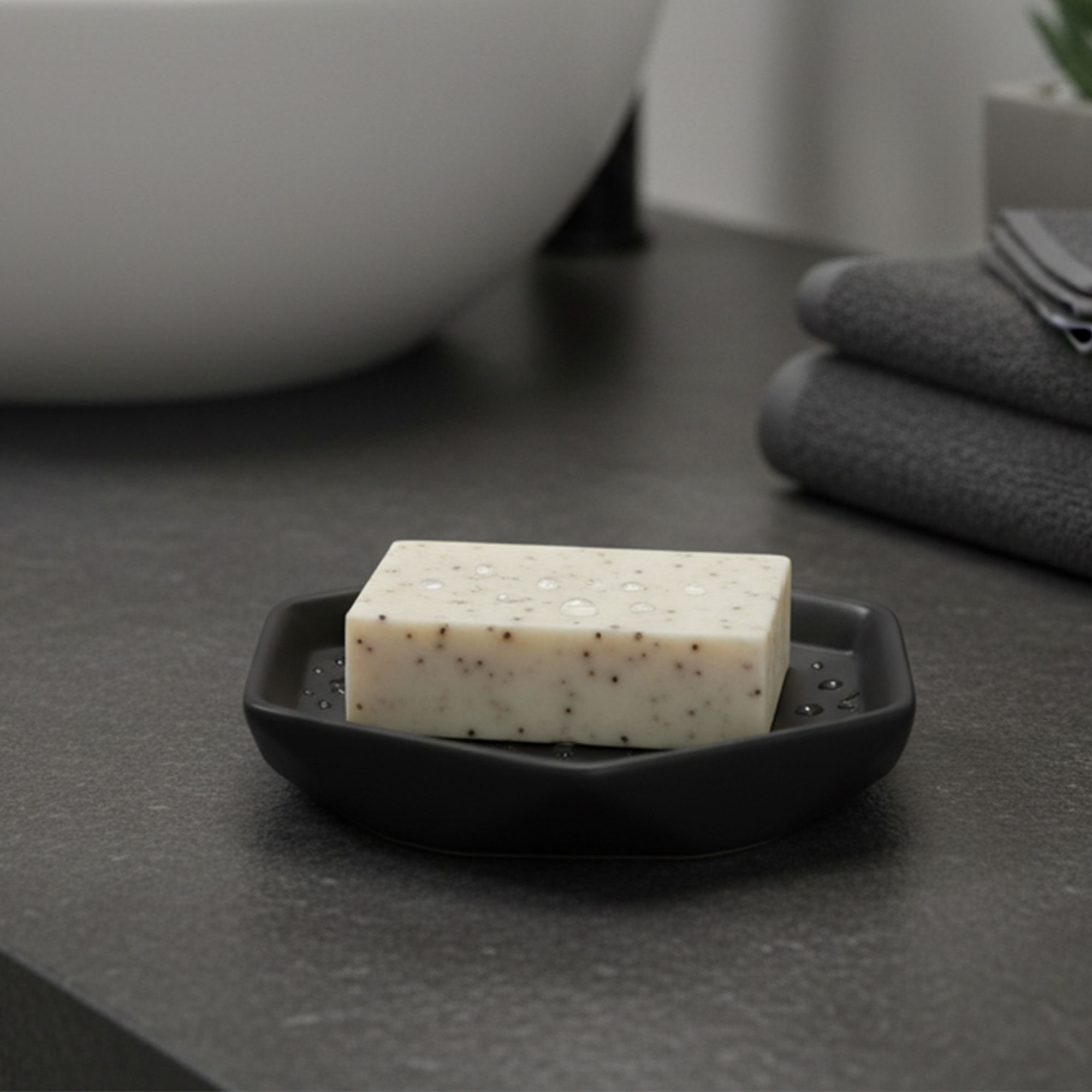Black soap dish holding bar soap on dark countertop