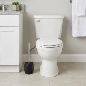 Black diamond-shaped stoneware toilet brush with stainless steel handle beside white toilet in modern bathroom