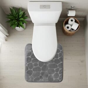 Top-down view of dark gray pebble-texture contour mat fitted around toilet base