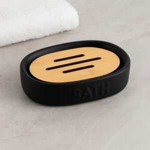 Black soap dish with bamboo insert on bathroom counter