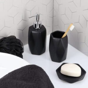 3. “Matte black soap dispenser and tumbler with geometric design on bathroom sink”