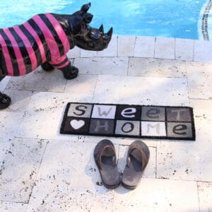 sweet home doormat near pool and flip flop