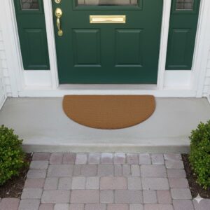 Half-moon natural coir doormat placed at green front door on porch paving