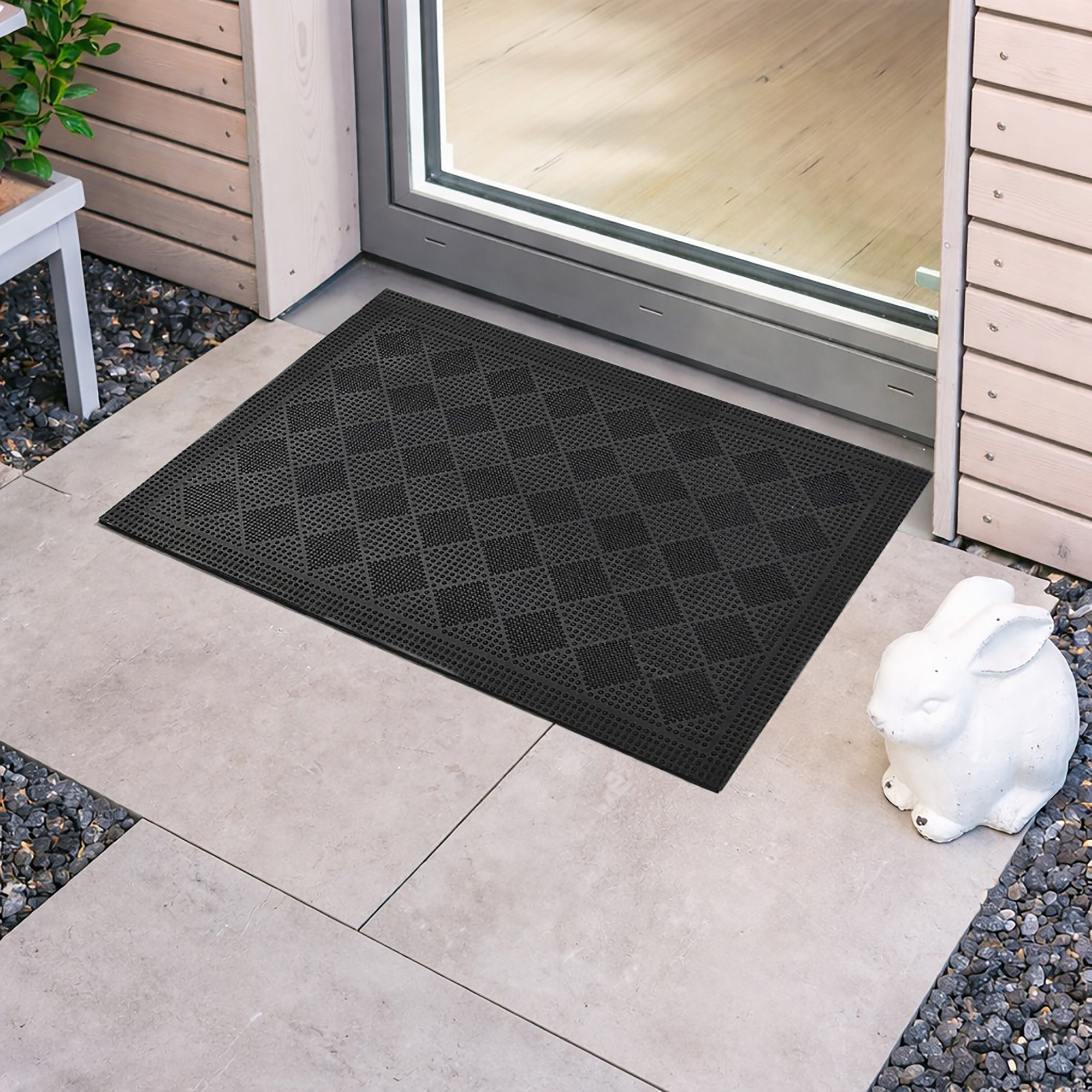 Black rubber checkerboard door mat placed in front of entry door