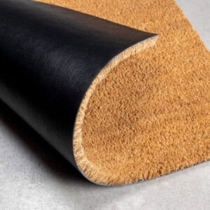 “Close-up of coir doormat with rolled black PVC backing”