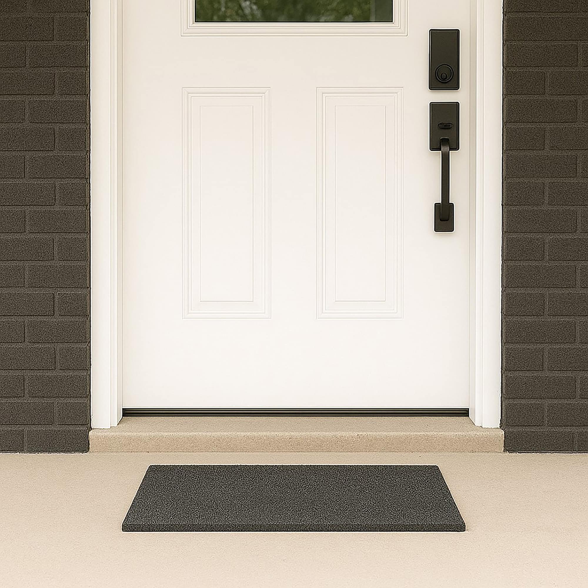“Grey coir doormat at white front door with dark brick exterior”