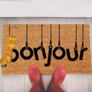 coco doormat in situation with boots and umbrella