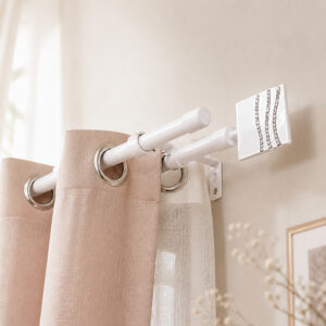 White double curtain rod mounted above a window, blush drape on the front rod and sheer panel on the back rod