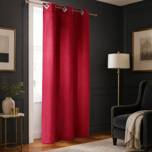 Ruby red suede curtain panel hanging at a living room window in soft vertical folds
