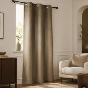 Warm sand suede curtain panel hanging at a living room window in soft vertical folds