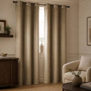 Pair of warm sand suede curtain panels hanging at a living room window in soft vertical folds