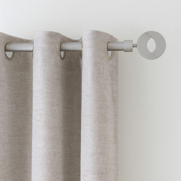 Grey curtain rod with circular finial holding a beige grommet curtain panel on a white wall