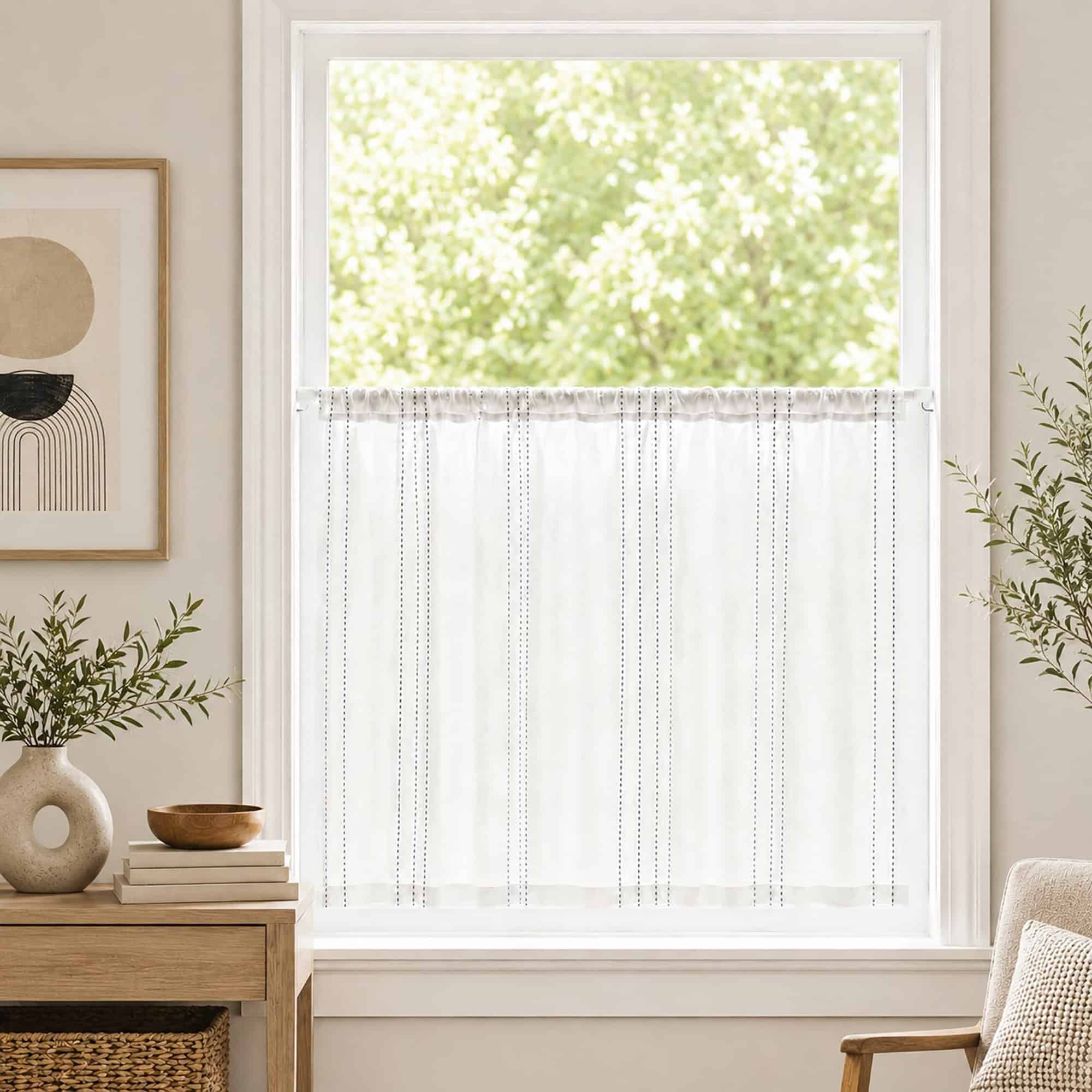 White cafe rod holding a sheer striped tier curtain across a bright kitchen window, styled with a green plant and light neutral decor for a farmhouse look.