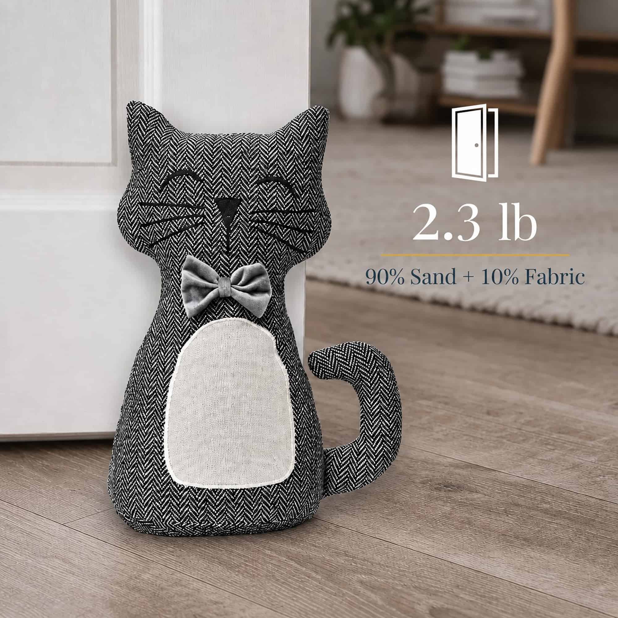 Charcoal cat door stopper propping a white door, with a door icon. On-image text: "2.3 lb," "90% Sand + 10% Fabric."