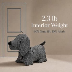 Charcoal dog door stopper on a taupe background with a line-drawn door. On-image text: "2.3 lb Interior Weight," "90% Sand fill, 10% Fabric."