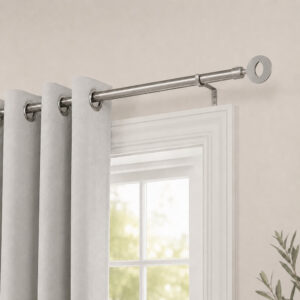 Grey single curtain rod with white grommet curtains hung over a living room window