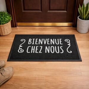 Bienvenue Chez Nous black PVC doormat placed in front of wooden interior door
