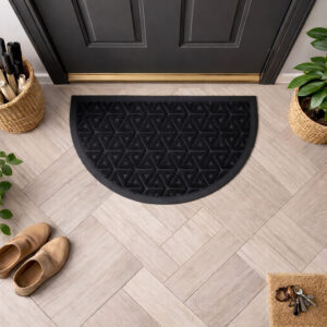 Top view of black half round door mat in front of dark door