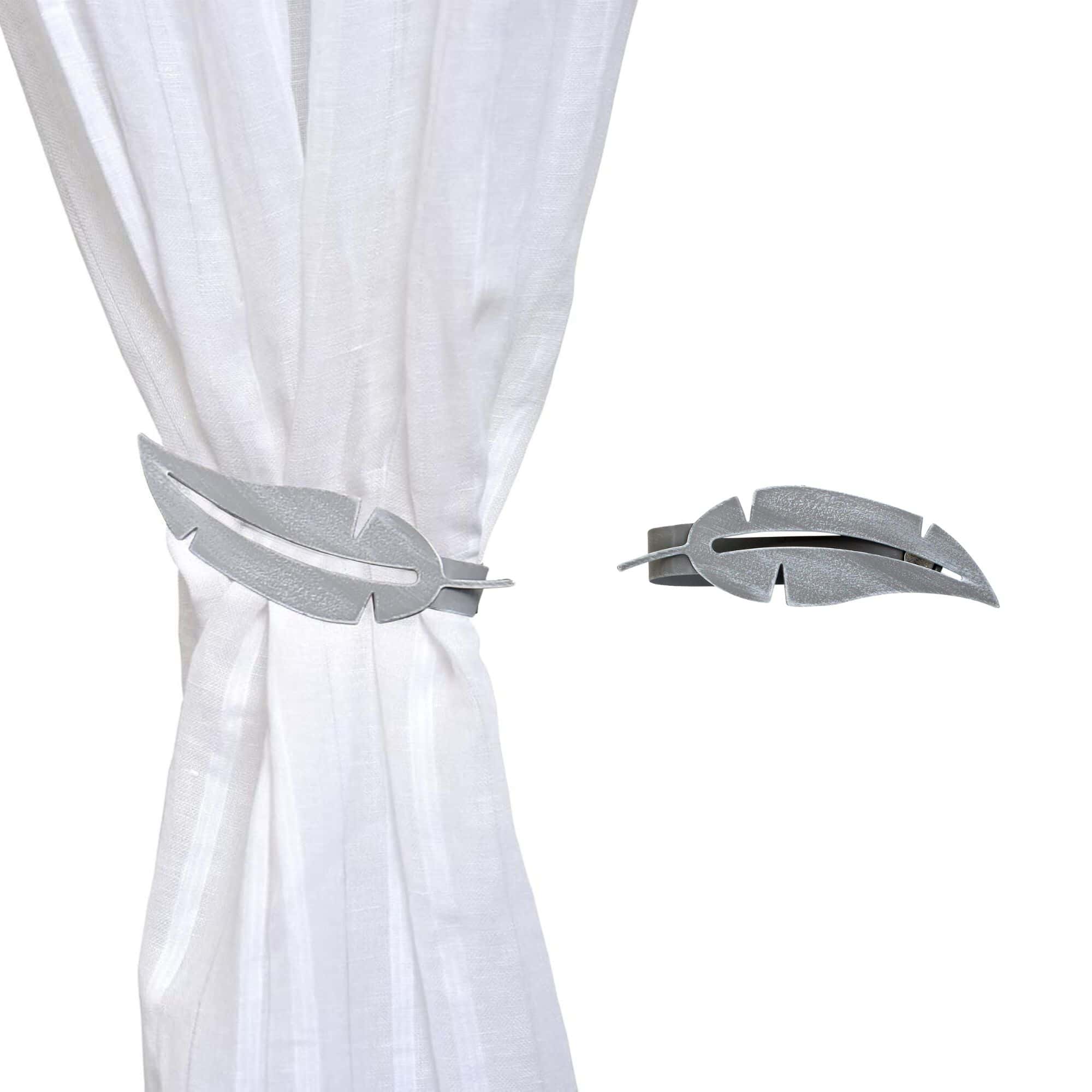 metal feather tieback on white curtain