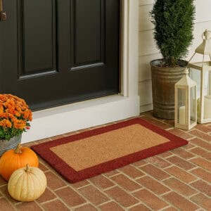 Red-border coir doormat 24x13 placed at front door on brick porch