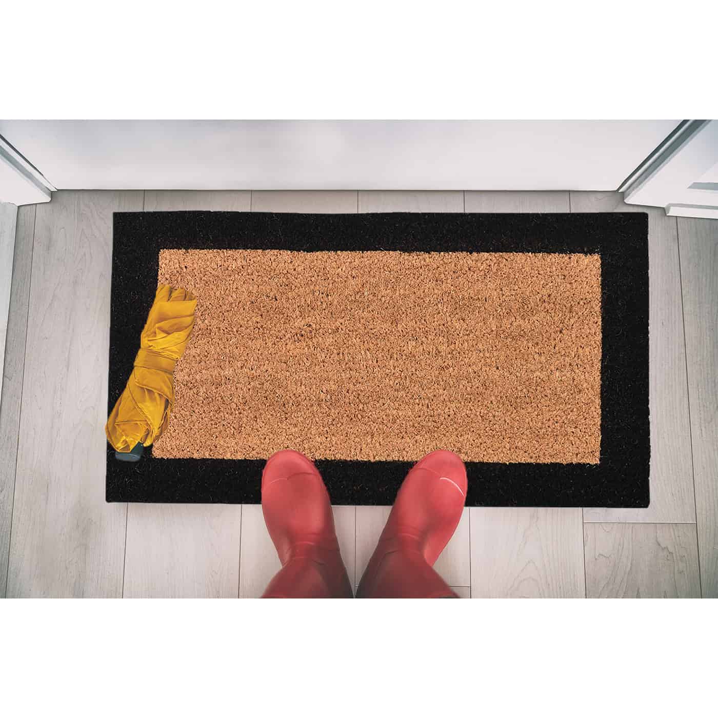 coco doormat in situation with boots and umbrella