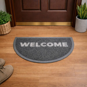 Indoor entryway with gray semi circle welcome doormat in front of wooden door